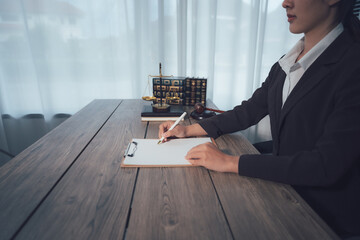 Legal Precision in Practice: A composed professional, meticulously poised at a wooden desk, engrossed in the precise task of documentation, her poised hand wielding a pen.