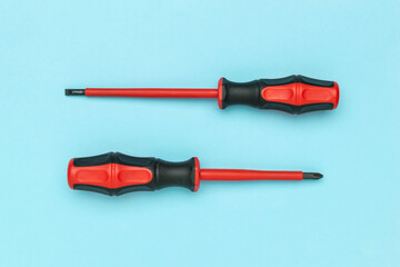 Top and Side View of Red and Black Screwdrivers on Blue Background