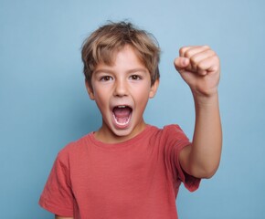 A young boy with a wide-open mouth and a clenched fist, expressing excitement or determination against a simple backdrop, showcasing a vibrant, energetic expression.