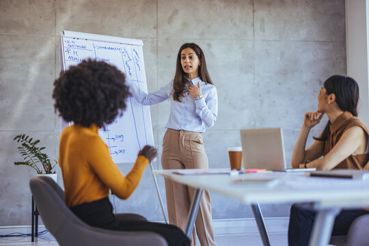 Confident Businesswoman Presenting Ideas During a Meeting in a Modern Office
