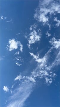 snow-white stripes of clouds on the bright blue sky in motion
