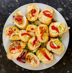 Assortment of Bruschetta Baguettes with Brie, Bacon, Red Pepper, Cheddar, Herbs on a Salad Bed