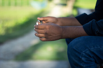 Closeup of hands holding a cigarette outdoors