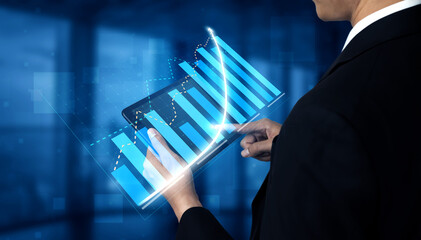 A businessman engages with a digital tablet showcasing bar graphs and projections in a modern office, symbolizing financial analysis and success. Impute