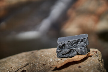 Handmade artisan black soap bars in the outdoors environment. Organic, sustainable, and plant-based skincare made for holistic wellness and everyday purity