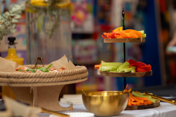 Beautifully arranged catering food, including sliced vegetables and appetizers, presented on a table at an event
