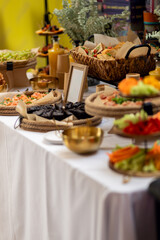 Elegant catering display presenting colorful appetizers, fruits, vegetables, and pastries arranged professionally on crisp white linen