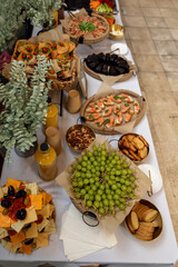 Beautifully arranged catering table featuring an assortment of appetizers, fresh fruits, and beverages, perfect for a sophisticated event