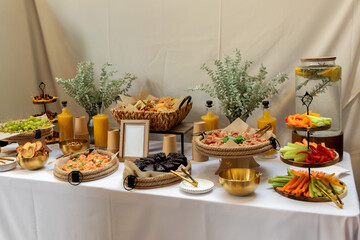 Beautifully decorated catering buffet table with a variety of delicious food, drinks, and...