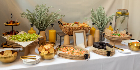 Delicious appetizers, canapés, finger food, and seasonal fruits arranged on a buffet table, ready...