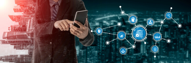 A businessman interacts with a smartphone amidst a vibrant urban backdrop at night. Digital icons illustrate technology and connectivity, emphasizing innovation. Tessel