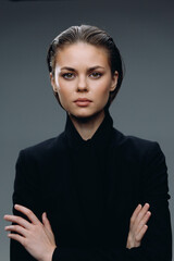 Serious woman in black clothes with crossed arms and confident expression