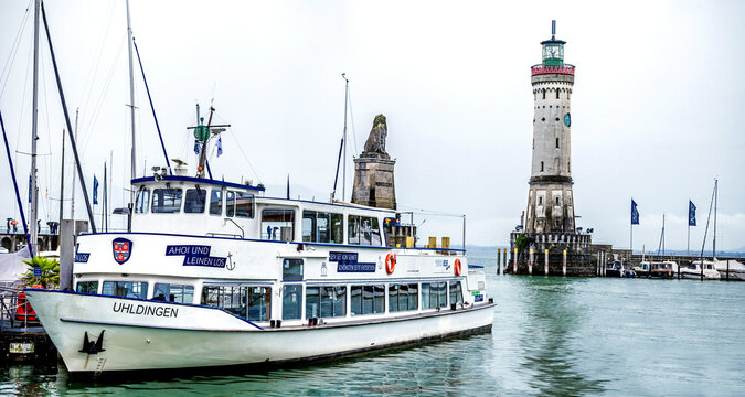 LANDAU, GERMANY - JULY 27, 2025: The Uhldingen ferry moored near Lindau Lighthouse on a cloudy July day.
