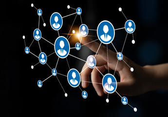 A hand interacts with a digital network showcasing user icons and connections, symbolizing the...