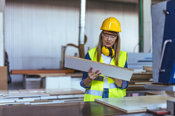 Female Worker in Hard Hat Examining Wood Panel in Manufacturing Facility