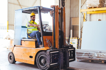 Worker Operating a Forklift in a Warehouse with Loading Equipment