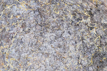 Gray metal texture background. Industrial abstract surface closeup. Rough metallic design with golden cracks. Modern construction material pattern. Hard surface texture macro. Decoration detail.