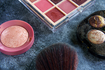Makeup products and tools arranged on a dark background. 