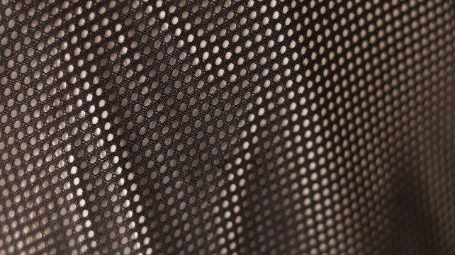 Elliptical mesh pattern stretched across soft fabric grid, abstract textile texture with light-shadow interplay and geometric rhythm
