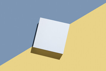 White cube, podium or box with shadow on diagonally divided yellow and blue background.