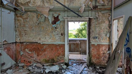 Doorway opening to balcony. Crumbling room walls, debris, peeling paint and wallpaper. Eerie...