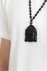 A Young Man in a White T-Shirt Wearing a Buddha Pendant