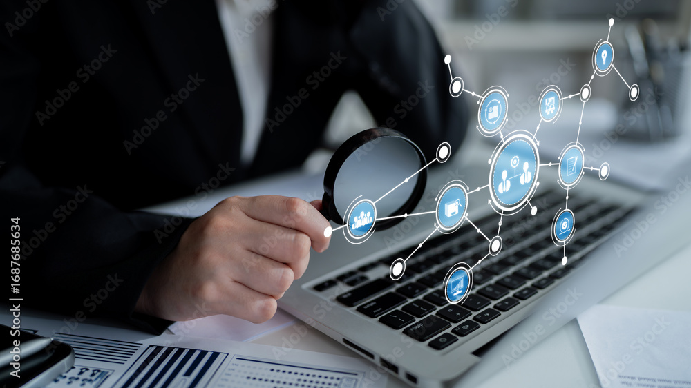 Poster a business professional uses a magnifying glass to analyze data displayed on a laptop in a modern wo