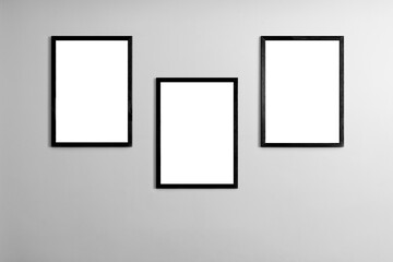 Modern minimal interior with one two three  four  five blank black  wooden photo frames light gray wall, mockup template for artwork, posters or prints, Scandinavian design, home decor, gallery wall