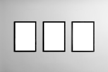 Modern minimal interior with one two three  four  five blank black  wooden photo frames light gray wall, mockup template for artwork, posters or prints, Scandinavian design, home decor, gallery wall