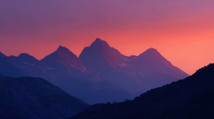 Obraz premium sunset mountain background with pink-orange sky and silhouetted peaks