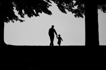 Silhouette of Father and Child Holding Hands in Forest