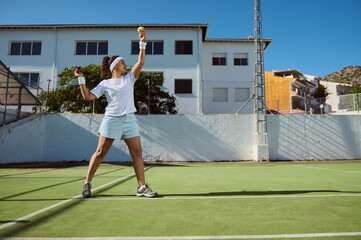 Female Tennis Player Preparing to Serve Ball on Outdoor Court