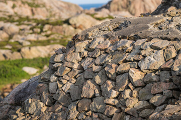 Close up view of stacked stone wall in rocky mountain landscape.