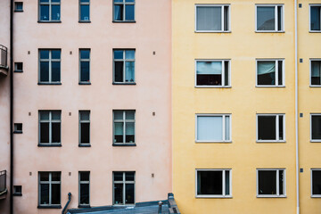 Facade of pastel pink and yellow apartment buildings.