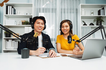 Smiling radio influencer hosts wearing headphones looking camera to pose on social online live...