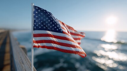 American flag flying over ocean pier with sunlight shining
