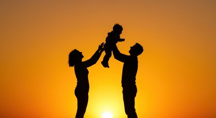 Silhouette of a happy family at sunset, parents joyfully tossing their baby in the air.