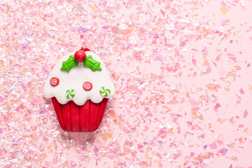 Vintage Plasticine clay cupcake on pink glitter background. Minimal Christmas concept. Happy New Year. Flat lay, top view, copy space