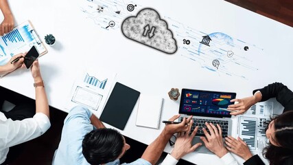 A diverse team gathers around a modern table using laptops and tablets to analyze cloud data, exploring business metrics and fostering innovative strategies collaboratively. Raster - Powered by Adobe