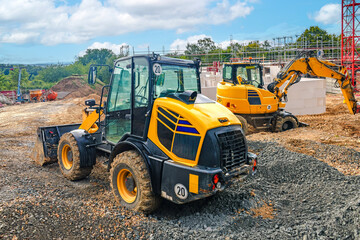 Yellow loader and excavator working on construction site
