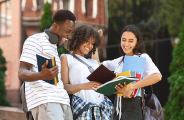 After Exam. Cheerful international students celebrating successful test pass, standing near...