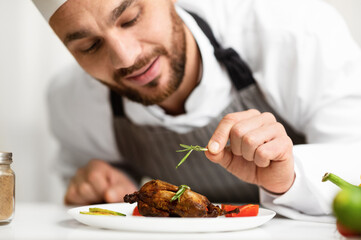 Cook Man Decorating Chicken Dish Preparing Dinner In Restaurant Kitchen Indoor. Cropped, Selective Focus