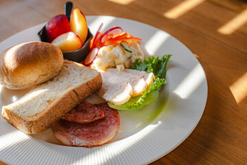 Healthy breakfast plate with bread, ham, chicken and fresh salad
