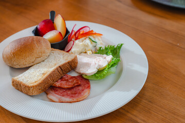 Healthy breakfast plate with bread, ham, chicken and fresh salad

