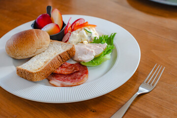 Healthy breakfast plate with bread, ham, chicken and fresh salad
