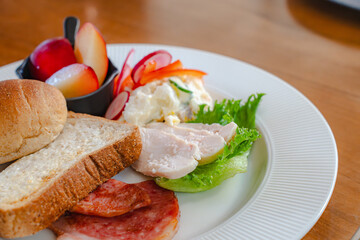 Healthy breakfast plate with bread, ham, chicken and fresh salad
