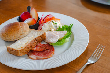 Healthy breakfast plate with bread, ham, chicken and fresh salad
