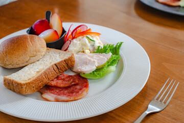 Healthy breakfast plate with bread, ham, chicken and fresh salad
