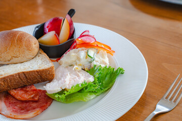 Healthy breakfast plate with bread, ham, chicken and fresh salad
