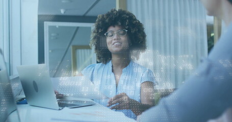 Speaking professional gesturing with digital overlay at office meeting table, with laptop, papers